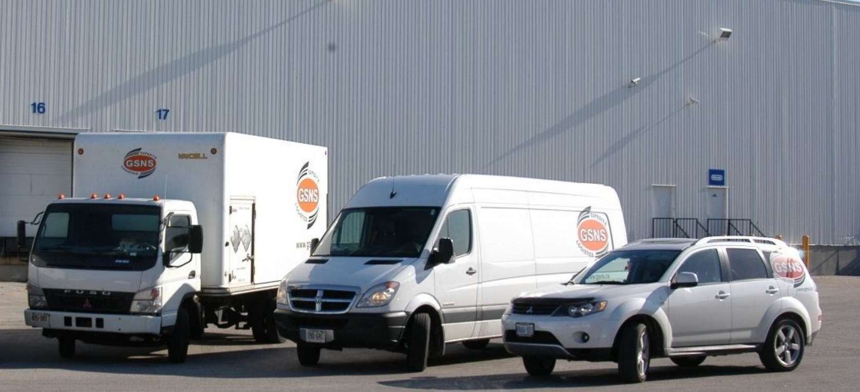 GSNS Logistics fleet — box truck, cargo van, and service vehicle at the Oshawa dispatch facility