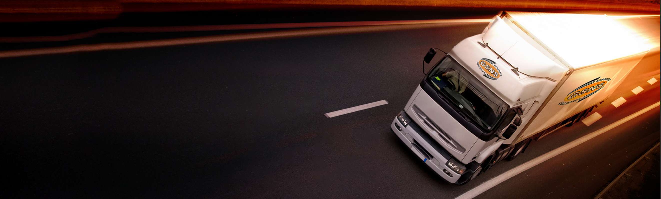 GSNS Expedite freight trailer on a night highway with motion-blur light streaks